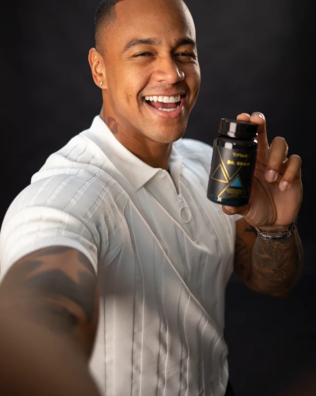 Léo Santana sorrindo e segurando o frasco de Dr. Brain Topway