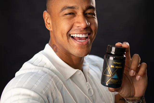 Léo Santana sorrindo e segurando o frasco de Dr. Brain Topway